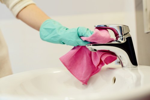 Local cleaner tidying a modern apartment kitchen in Soho