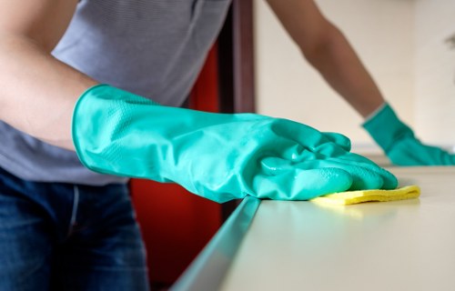 Cleaner working on residential windows in a Soho flat above shops